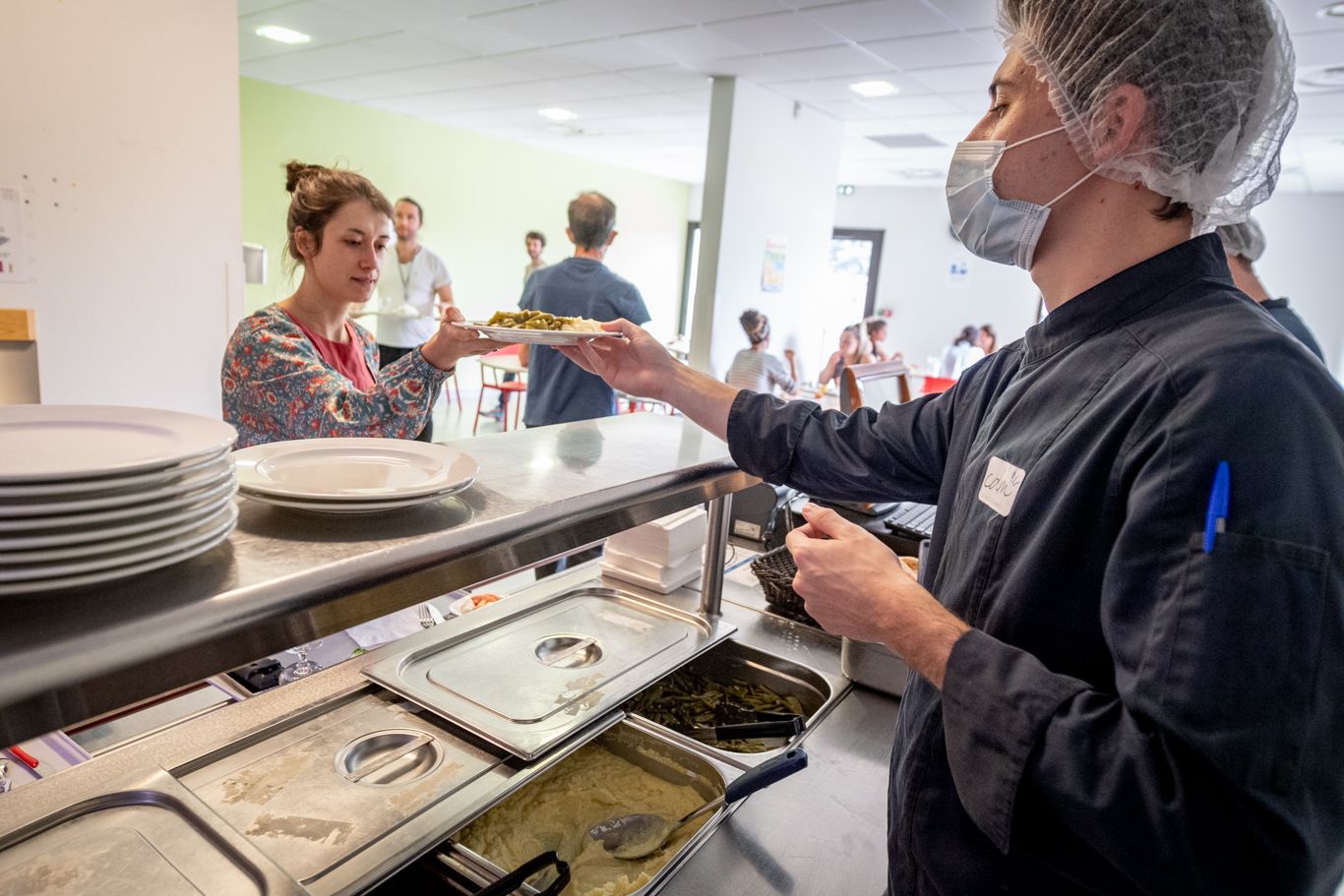 Photo illustrant un membre de l'équipe restauration servant une accompagnante au sein de l'espace restauration de la clinique des minimes